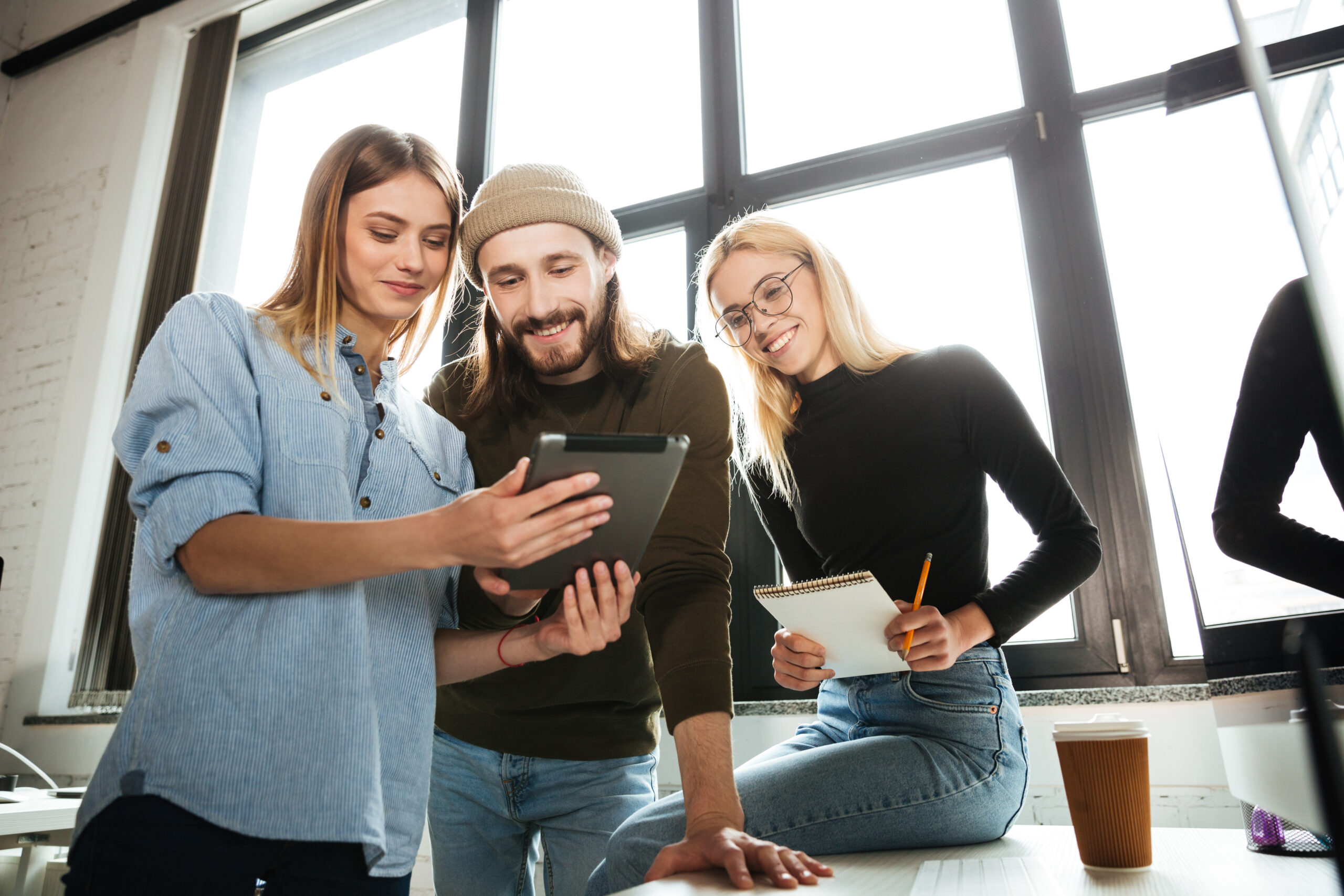 Young colleagues standing in office using tablet computer Social commerce Pullover